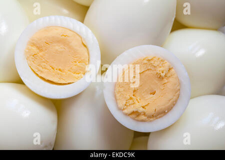 peeled hard boiled eggs with one cut in half on top Stock Photo