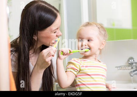 cute mom teaching child teeth brushing Stock Photo