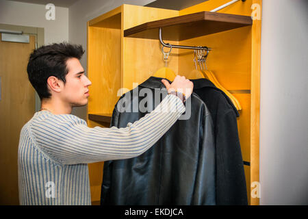 Handsome Man Hanging his Coats Inside his Wardrobe Stock Photo