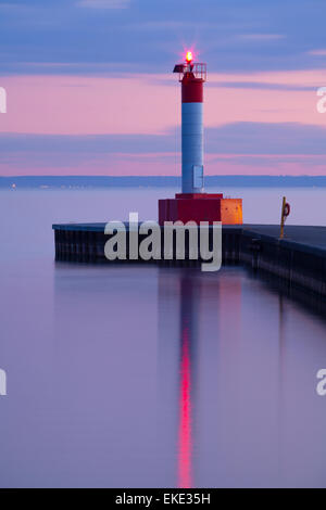 A lighthouse during a colourful sunset on Lake Ontario at Waterworks Park in Oakville, Ontario, Canada.