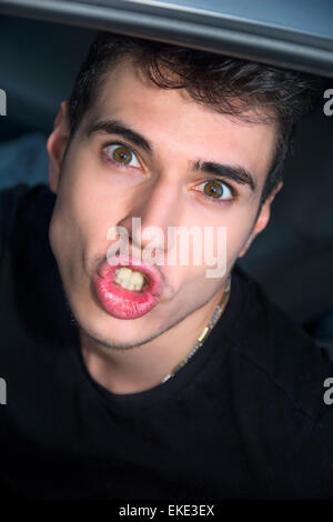 Funny Young Man Face with Pouting Lips and Wide Eyes Stock Photo