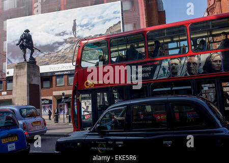 A giant billboard ad for the use of iPhones seen on the side of a central London building, juxtaposed with bus advertising and a WW1 memorial soldier of the Royal Fusiliers. Stock Photo