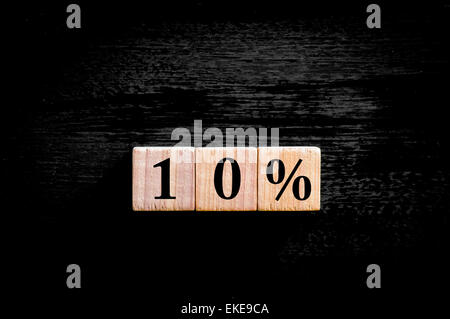 Ten percent symbol. Wooden small cubes with letters isolated on black background with copy space available. Concept image. Stock Photo