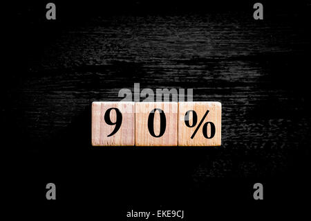 Ninety percent symbol. Wooden small cubes with letters isolated on black background with copy space available. Concept image. Stock Photo