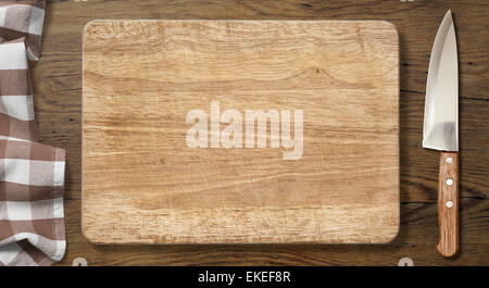Cutting board and knife on old wood table with picnic tablecloth Stock Photo