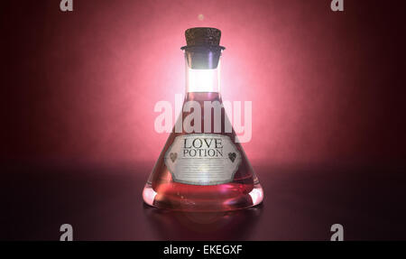 A regular old goblet glass bottle filled with a pink liquid with a label showing it is love potion and sealed with a cork on a s Stock Photo