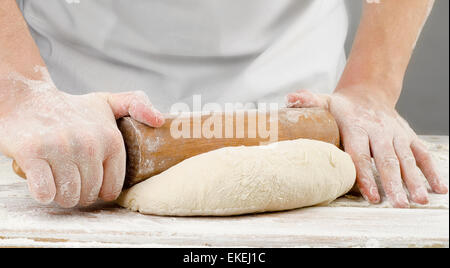 Hands preparing dough with rolling pin . Selective focus Stock Photo