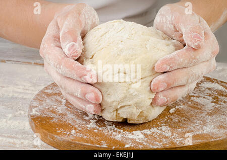 Woman Hands preparing dough  on  wooden table. Selective focus Stock Photo