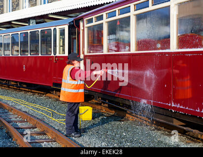 Woman washing train carriage, at Porthmadog Station on the Ffestiniog Railway, Gwynedd, North Wales UK Stock Photo