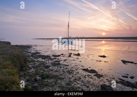 Faversham creek, Kent, UK. 10th April 2015. UK weather. A cool, misty and hazy sunrise over Faversham creek in Kent as poor air quality and high levels of air pollution caused by a combination of traffic fumes and Saharan dust are forecast for the South east with temperatures up to 20°C later today Stock Photo