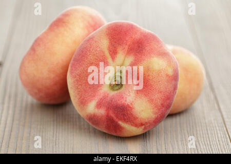 flat peaches on wood table Stock Photo