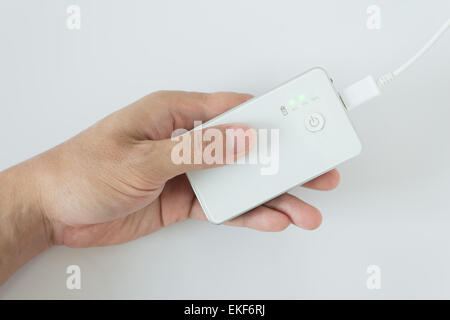 male hand plugging in the wall electtric plug of his power bank in a socket Stock Photo