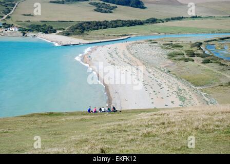 Walkers sitting overlooking Cuckmere Haven near Seven Sisters chalk cliffs, East Sussex, UK Stock Photo
