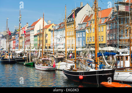 Colourful façades of 17th and 18th century townhouses and historic ships line Nyhavn canal, Copenhagen waterfront, Denmark Stock Photo