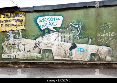 Saint-Petersburg, Russia - April 6, 2015: Graffiti with crocodile in the car on old green concrete wall. Advertisement text Stock Photo