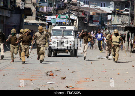 Srinagar, Kashmir. 10th April, 2015. Kashmiri Muslim protester throws a stone towards Policemen in Maisuma area of Srinagar the summer capital of Indian administered Kashmir on April 10,2015.Protests escalate  against the separate townships for Kashmiri Pandits. Jammu and Kashmir Chief Minister Mufti Mohammad Sayeed has accepted the demand for creating separate zones for Kashmir Pandits in the state. Credit:  NISARGMEDIA/Alamy Live News Stock Photo