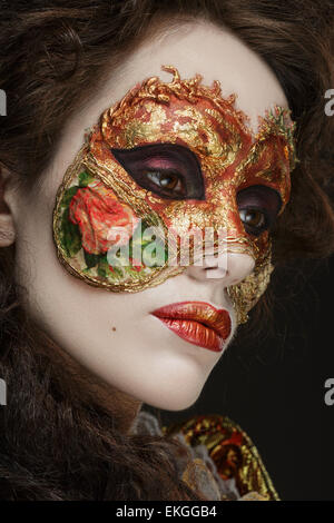 Faceart. Venetian mask. Close-up portrait of Beautiful woman in vintage dress and a mask on his face.