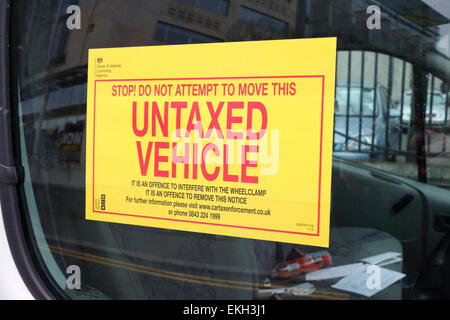 warning sticker attached to window of vehicle clamped for unpaid vehicle tax Stock Photo