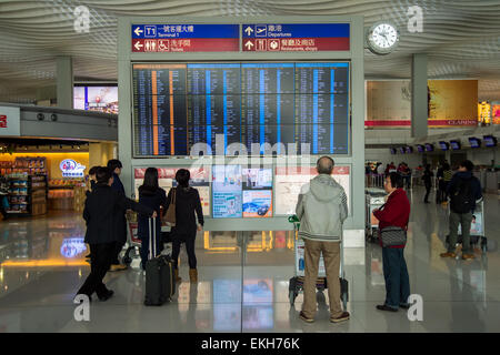 Passengers looking at departure display at Hong-Kong airport Stock Photo