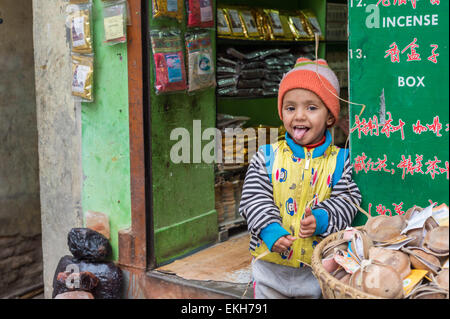 Nepali boy in front of an incense shop in Kathmandu Stock Photo