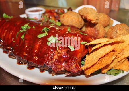 Tex mex BBQ baby back ribs and wings platter with nachos Stock Photo