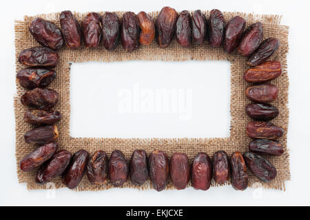 Frame made of burlap with dried date, on a white background Stock Photo