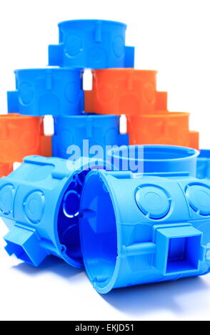 Blue and orange plastic electrical boxes on white background, components for use in electrical installations, Stock Photo