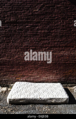 Old and dirty Abandoned Mattress in a Backstreet Stock Photo