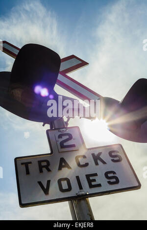 Two Train Track Sign and Light with Sunlight in Background Stock Photo