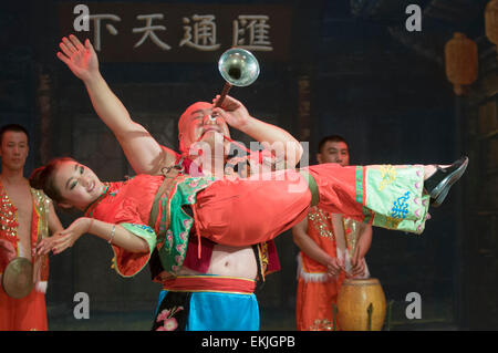 Performer blows horn through his nose  during stage show in the ancient walled city of Pingyao, Shanxi Province, China Stock Photo