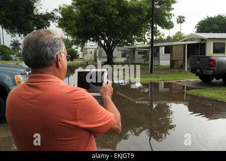 Resident capturing April flooding in a mobile home/RV Park on his tablet computer in Mission, Texas, USA Stock Photo