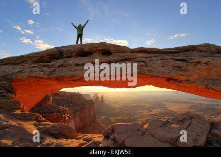 Silhouetted person standing on top of Mesa Arch, Canyonlands National Park, Utah