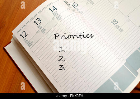 Priorities Concept Business Notepad on wooden table Stock Photo