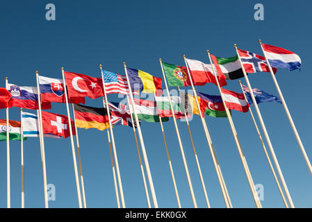 flags of different countries on flagpoles fluttering in the wind Stock Photo