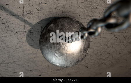 A regular metal wrecking ball attached to a chain hitting a concrete surface Stock Photo