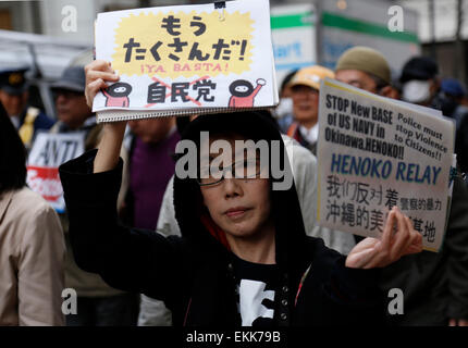 Tokyo, Japan. 11th Apr, 2015. A woman holds a placard during a demonstration to protest against the revision of the pacifist Article 9 of the Japanese Constitution in Tokyo, Japan, April 11, 2015. Some 30 people participated in this protest. Credit:  Stringer/Xinhua/Alamy Live News Stock Photo