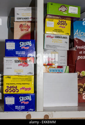 Kitchen cupboards full of mini cereal packets as well as regular sized cereal packets. Stock Photo