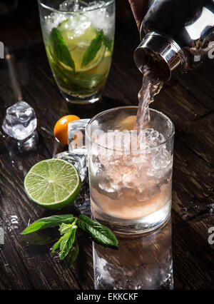 Pouring a cocktail into glass, close-up. Stock Photo