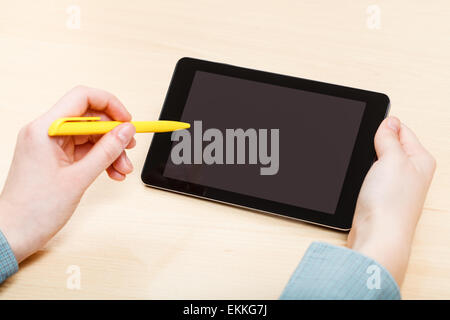businessman touches by pen of tablet PC with black screen at office table Stock Photo