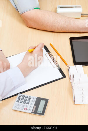 medic makes appointment and measures blood pressure of patient Stock Photo