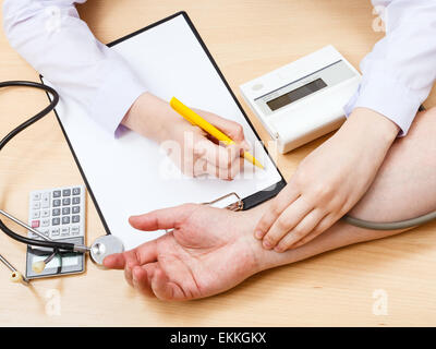 doctor makes appointment and measures blood pulse of patient Stock Photo