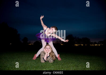 Two teenage girls dress up and pose at night Stock Photo