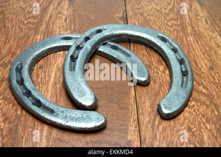 Cast iron horseshoes on wood planks Stock Photo