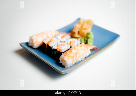 Blue sushi plate with hosomaki and nigiri selective focus on white background Stock Photo