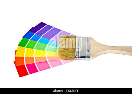 Paint brush on colorful paint chips isolated on white. Stock Photo