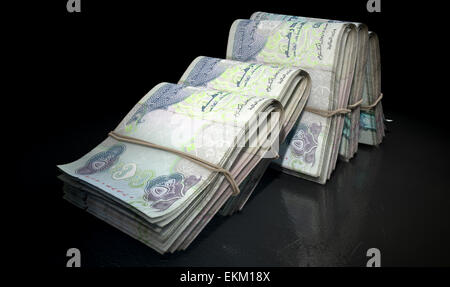 A close-up view of five wads of folded over stacks of dirham banknotes each bound informally by a rubber band set out Stock Photo
