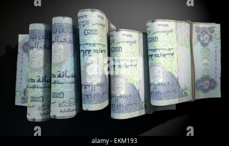 A close-up view of five wads of folded over stacks of dirham banknotes each bound informally by a rubber band set out in a Stock Photo