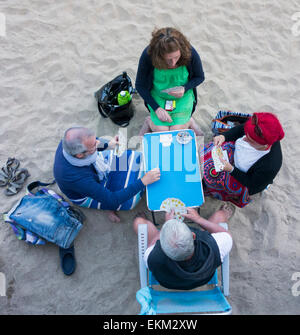 Saturday 11th, April 2015, Las Palmas, Gran Canaria, Canary Islands, Spain. Weather:  Locals playing cards at sunset on Las Canteras beach in Las Palmas, the capital of Gran Canaria Stock Photo