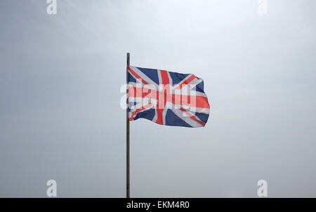 Union Flag flying against a white background sky Stock Photo