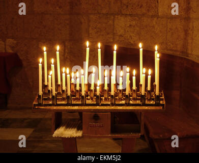 A candle holder in a church with lighted candles Stock Photo